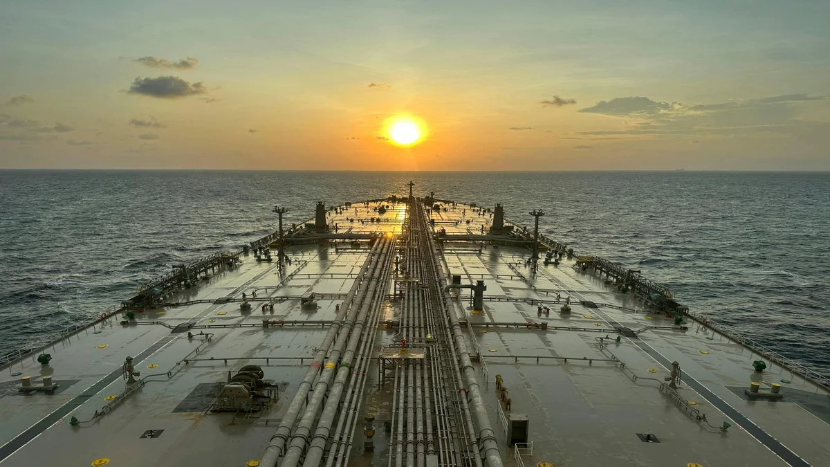 Navio petroleiro navegando no oceano ao por do sol, representando as rotas maritimas em disputa no Estreito de Ormuz
