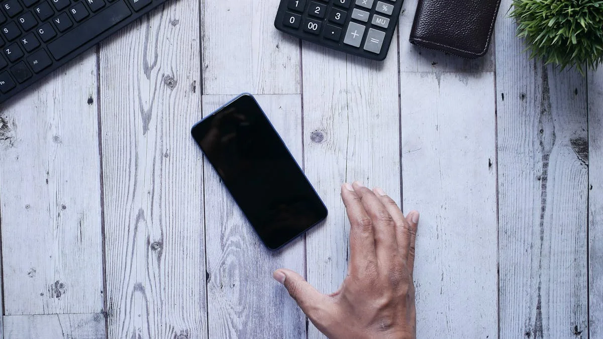 Mao alcancando um smartphone sobre uma mesa de escritorio, representando comunicacao digital e redes sociais