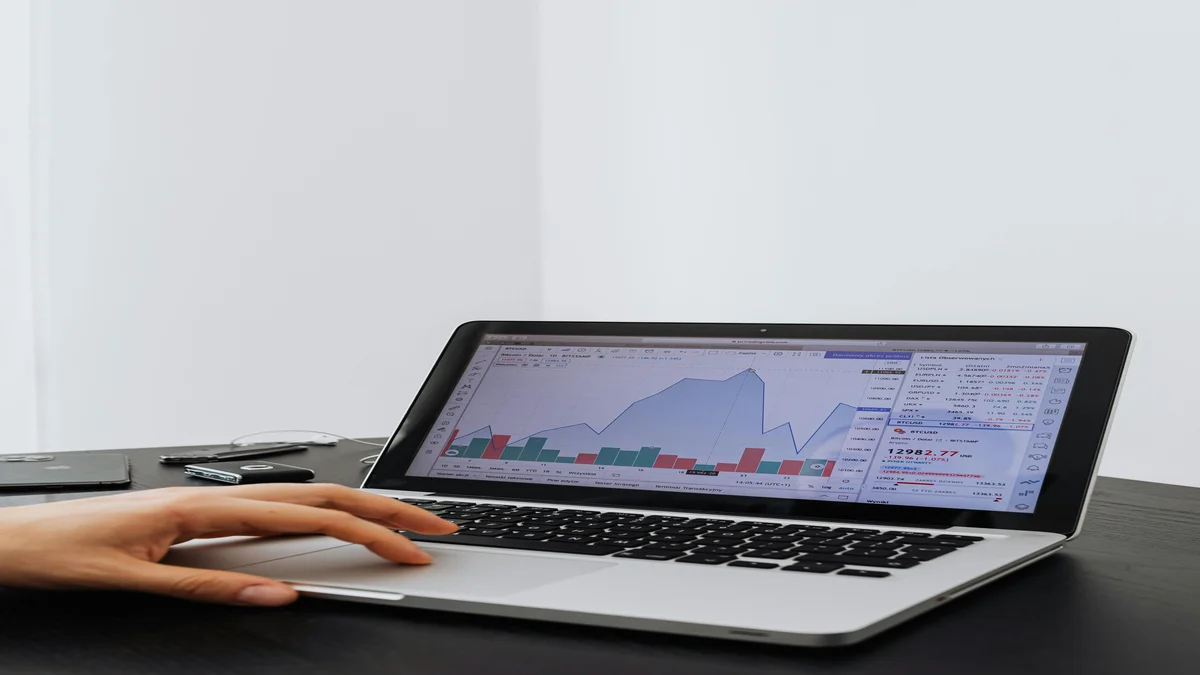 Pessoa analisando graficos de trafego em laptop mostrando queda no acesso organico