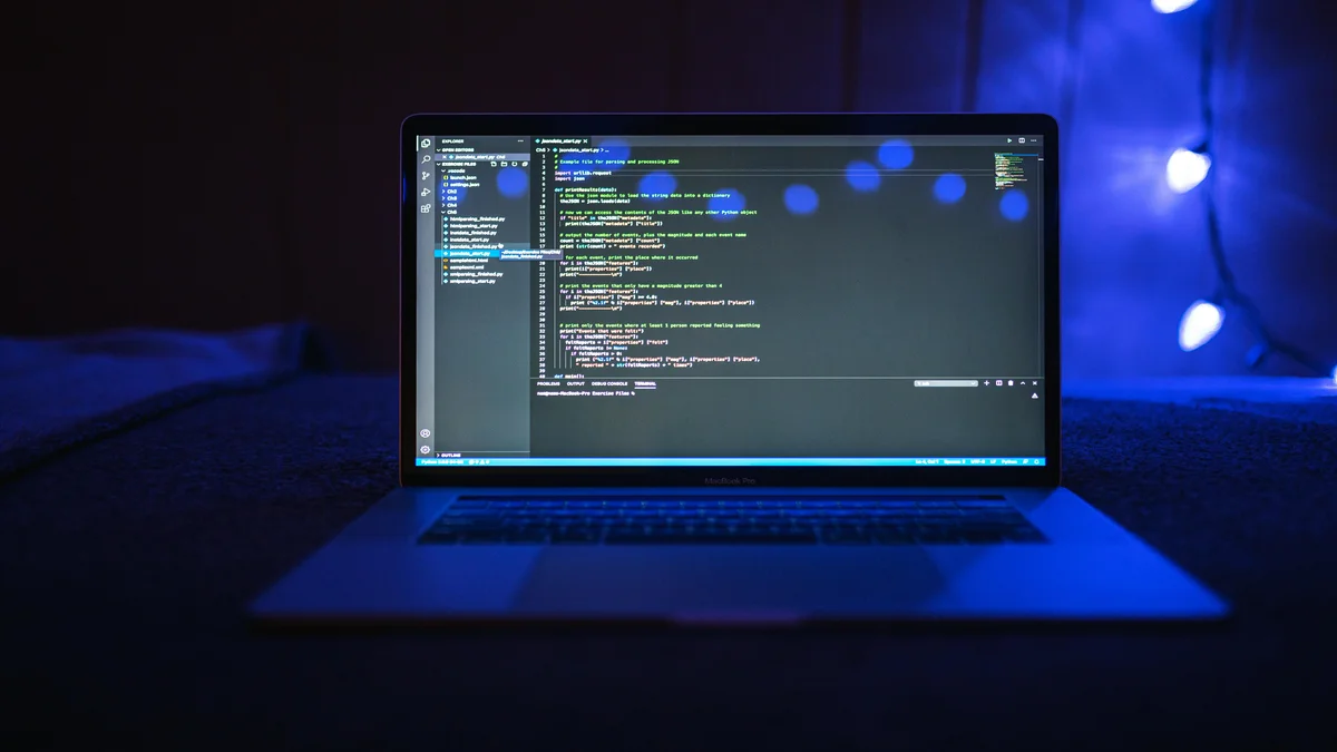 Tela de laptop exibindo codigo de programacao com luz azul, representando tarefas de programacao do Claude Fable 5