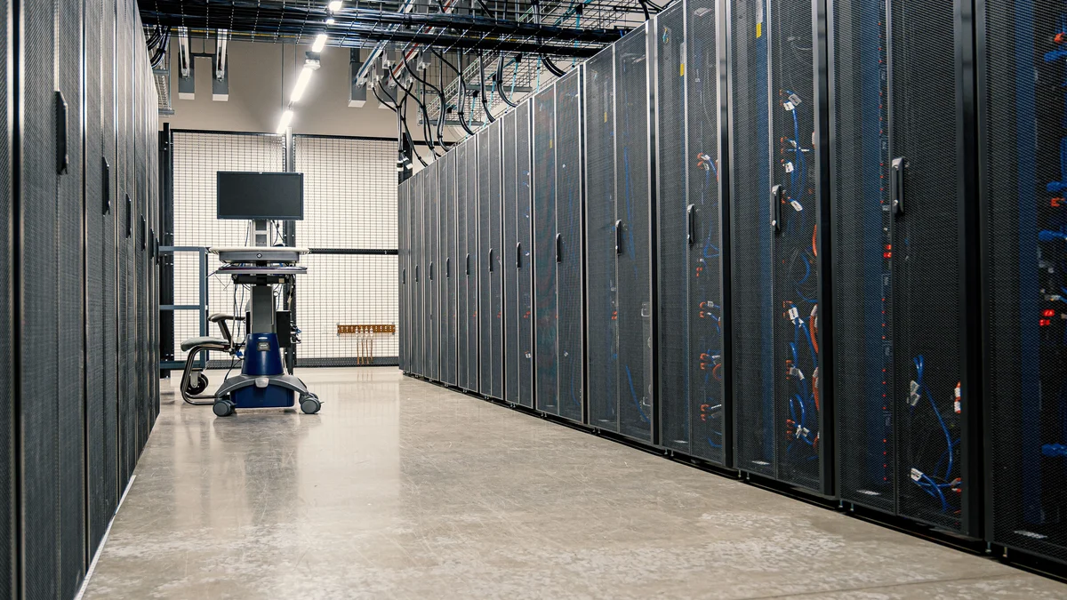 Corredor de data center com racks de servidores, representando a disponibilidade do Claude Fable 5 na nuvem