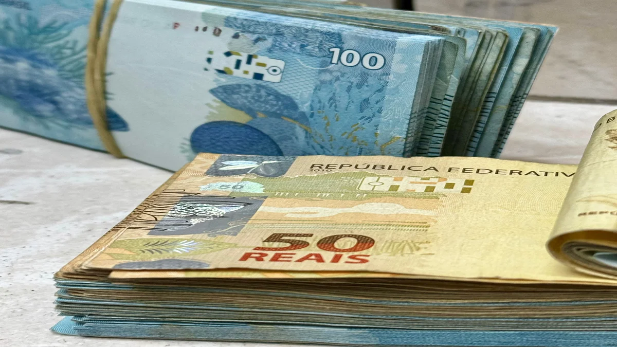 Pilhas de notas de real brasileiro, representando o pedido de R$134 milhoes de Flavio Bolsonaro a Daniel Vorcaro para o filme Dark Horse
