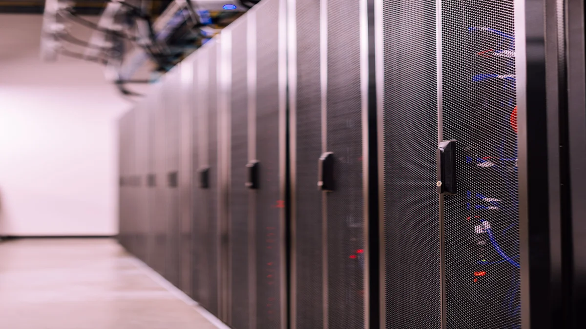 Servidores em data center com cabos de fibra optica em corredor iluminado