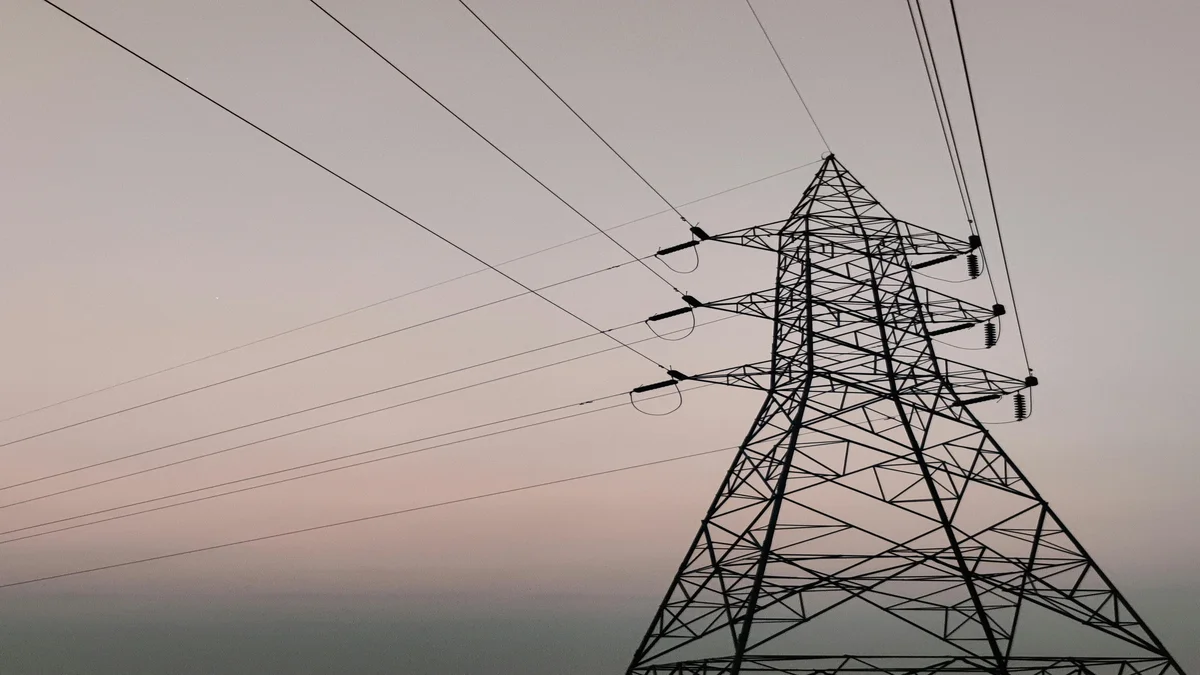 Torre de transmissão de energia elétrica contra céu ao entardecer, representando a infraestrutura energética que sustenta data centers de IA