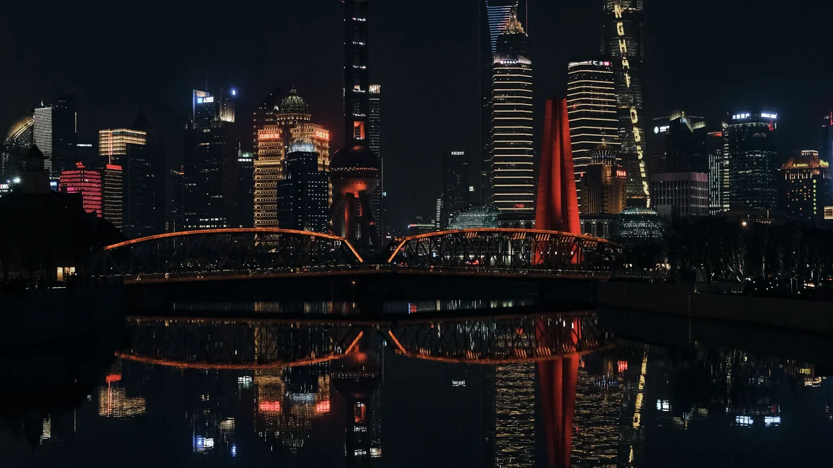Skyline de Shanghai iluminado à noite, representando o centro tecnológico chinês onde modelos de IA como o Kimi K3 e o Qwen 3.8-Max foram lançados